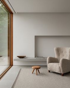 a living room with a chair and table next to a large sliding glass door that looks out onto the outdoors