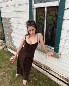 a woman standing in front of a window with her hands out and holding a ball