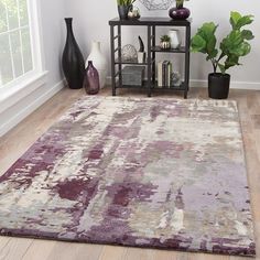 a living room area with a rug, vases and other decorative items on the floor