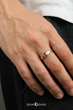 a man's hand with a gold ring on it