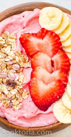 a bowl filled with fruit and granola on top of a table