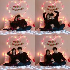 two people sitting on a bed in front of a heart with merry christmas written on it