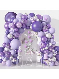 a purple and white balloon arch with butterflies