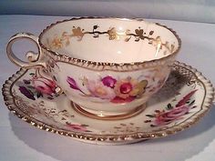 an antique tea cup and saucer decorated with flowers