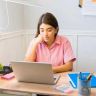 a woman sitting at a table with a laptop in front of her