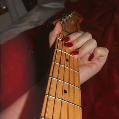 a woman's hand holding an electric guitar