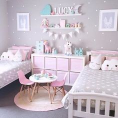 a room with two beds and pink furniture