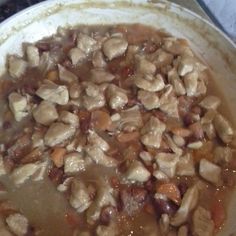 chicken and carrots cooking in a pot on the stove