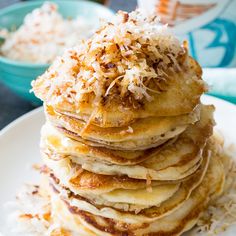 a stack of pancakes topped with coconut flakes