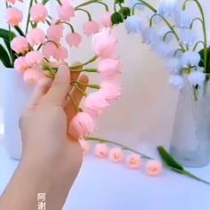 a person is arranging pink flowers in a vase