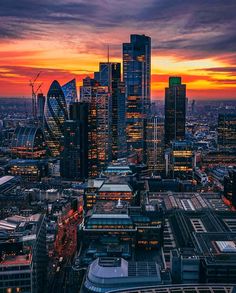 an aerial view of the city skyline at sunset, with skyscrapers in the foreground