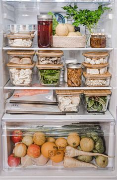 an open refrigerator filled with lots of different types of vegetables and fruit in containers on the shelves