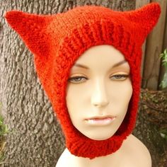 a mannequin head wearing a red knitted cat ear hat with ears on it