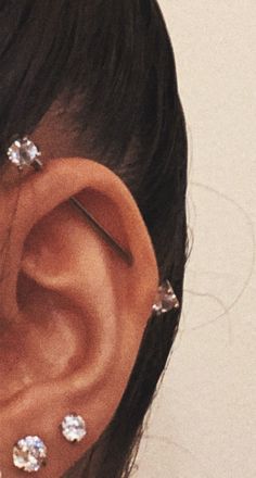 a close up of a person's ear with some piercings on it,