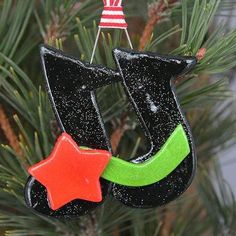 a christmas ornament hanging from a pine tree with a red star on it