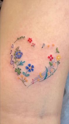 a woman's stomach with flowers and musical notes in the shape of a heart