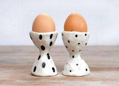 two ceramic eggs in polka dot designs on a wooden table