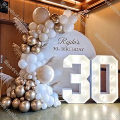 a 30th birthday party with balloons and lights in the shape of an arch that reads 30