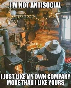 a man with a cowboy hat sitting in front of an old fashioned stove and oven