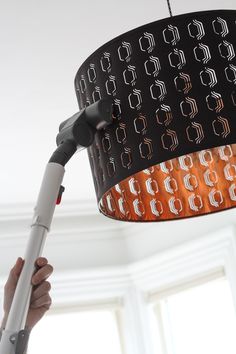 a person is holding up a light fixture