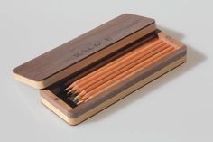 a wooden box filled with pencils on top of a table