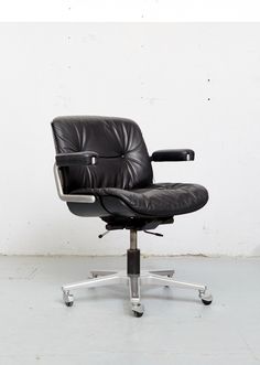 a black office chair sitting on top of a white floor