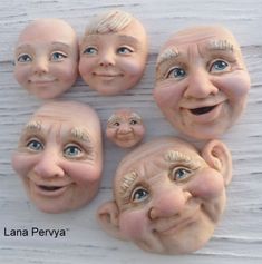 five clay faces with different facial expressions on them, one is smiling and the other has blue eyes