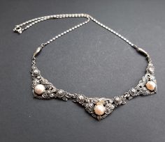 Lovely Antique Art Deco Czech necklace which dates to the 1920s. Three central raised panels set with little marcasite and each with a centrally set pearl. Chain and spring ring fastening. Drop length approx 19.5/20cm In beautiful condition. 💐Buy as much as you like for only one shipping charge we don't charge extra for any additional item💐 Please look at all photographs carefully as they form part of the description. We do our best to describe things as accurately as possible. Our items are all vintage and will have some wear unless stated. We do highlight any damage. Packaging & Postage - all items are sent fully tracked and will arrive carefully wrapped in a delivery box. All packaging is recyclable. We aim to post within 3 working days of payment. Thank you! Jane & Nix Czech Necklace, Czech Art, The 1920s, Antique Art Deco, Pearl Chain, Antique Art, Spring Rings, Necklace Etsy, Jewelry Necklace Pendant