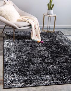 a black rug with a white chair and potted plant in the corner next to it