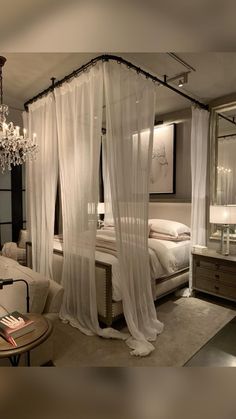 a bedroom with a canopy bed and chandelier