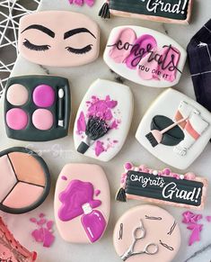 some decorated cookies are on a table with pink and black decorations, such as eyeshades