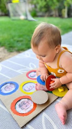 a baby sitting on top of a table playing with paper circles