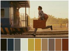 a man is running on the train tracks with luggage in his hand and color swatches below him