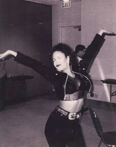 a woman is dancing in a black and white photo