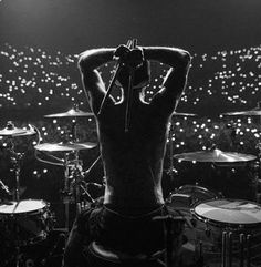 a man with his back to the camera and drums in front of him