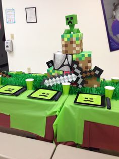 a table topped with cake and cupcakes on top of green cloth covered tables