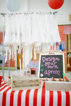 there is a sign that says design your own apron on the table in front of it