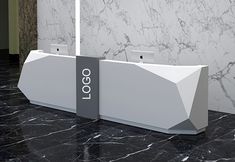 two white marble counter tops with logos on them in front of a black and white wall