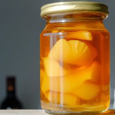 a jar filled with oranges sitting on top of a table