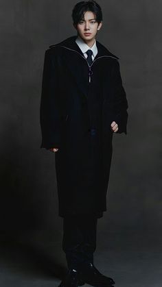 a young man in a black coat and tie