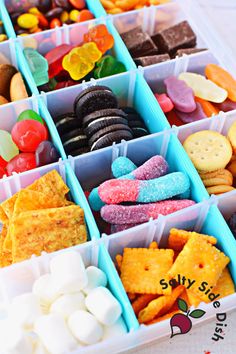 a plastic container filled with lots of different types of candy and crackers in it