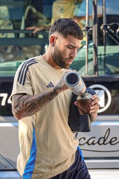 a man with tattoos holding a hair dryer