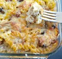 a casserole dish with pasta, meat and vegetables in it is being eaten by a fork