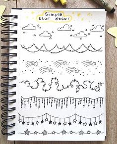 a spiral notebook with stars and clouds on the cover, next to some crayons