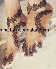 henna on the feet of a woman with flowers and leaves painted on her legs