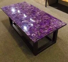 a purple marble coffee table sitting on top of a carpeted floor