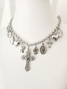 Religious Saints Necklace - Medals and Crosses in Stainless Steel Catholic Medals Necklace Gift for her, Catholic Christmas Gift, Multi charms necklace This stunning Catholic Saints Necklace is designed for those looking for a unique and meaningful accessory. Made from high quality stainless steel, this necklace is a durable piece that is resistant to daily wear and tear, ideal for expressing your faith in style. The necklace features a Sacred Heart cross in the center, surrounded by multiple me Silver Symbolic Necklaces With Dangling Charms, Silver Necklaces With Dangling Charms, Silver Cross Necklace With Charms, Silver Necklaces With Dangling Charms For Gift, Silver Spiritual Necklace With Vintage Charm, Spiritual Silver Necklace With Vintage Charm, Handmade Silver Necklace For Christmas, Catholic Christmas Gifts, Guadalupe Necklace