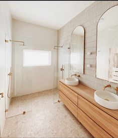 a bathroom with two sinks and a large mirror on the wall next to each other