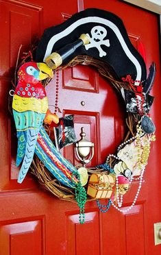 a wreath is decorated with pirate items and beads on the front door's red door