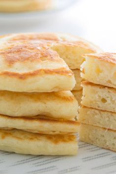 a stack of pancakes sitting on top of a white plate next to a pile of pancakes